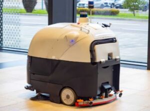 An auto-scrubber cleaning a large resilient floor in a commercial space
