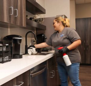 A commercial cleaner wiping down a high-touch surface in a Sioux Falls office breakroom