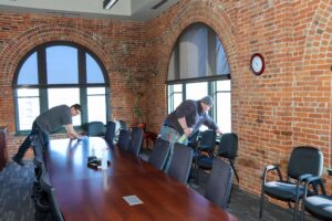A commercial cleaning crew tidying up a conference room in a Sioux Falls office