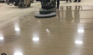 A diamond floor pad on an auto-scrubber polishing a commercial concrete floor

