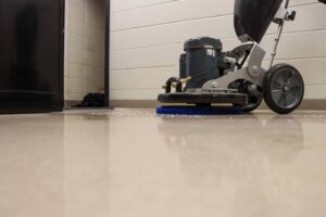 A floor machine with a pad running across a large commercial floor
