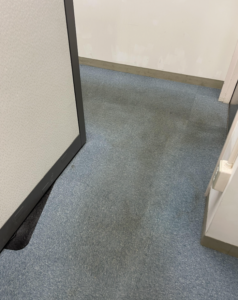 A worn, soiled carpet in a high-traffic commercial entrance in Sioux Falls
