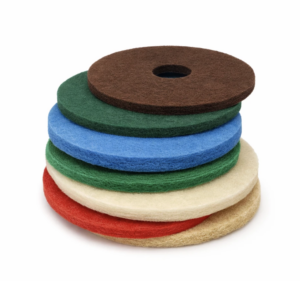 Color-coded commercial floor pads stacked in a Sioux Falls janitorial supply area